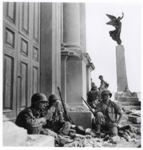 Soldati americani a Troina, nei pressi della cattedrale di Maria Santissima Assunta, dopo il 6 agosto 1943 Ph.Robert Capa © International Center of Photography/Magnum  – Collezione del Museo Nazionale Ungherese